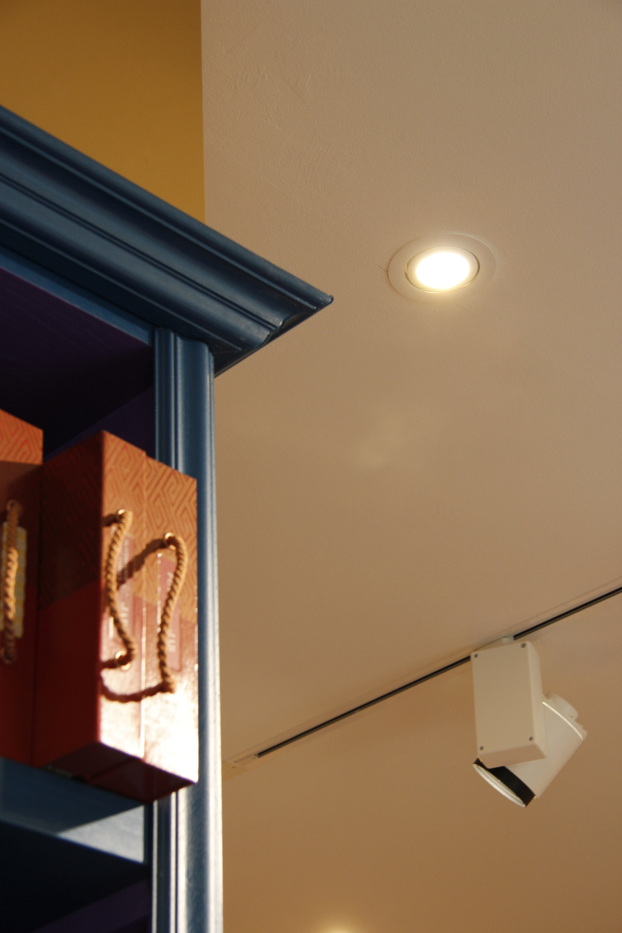 Architectural detail looking towards the ceiling spotlight and crown molding