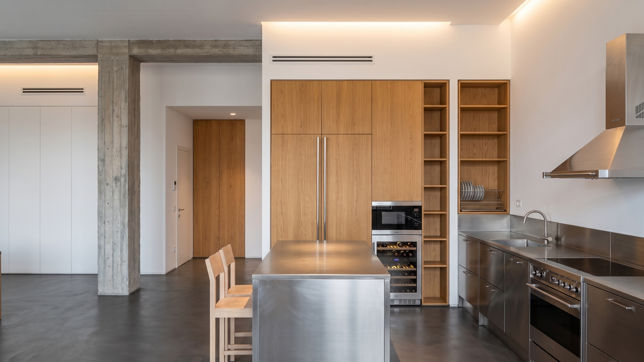 Stainless steel and raw oak elements interacting in the open living area